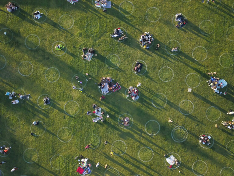 Shot from above of people sitting in social distance circles at Dolores Park