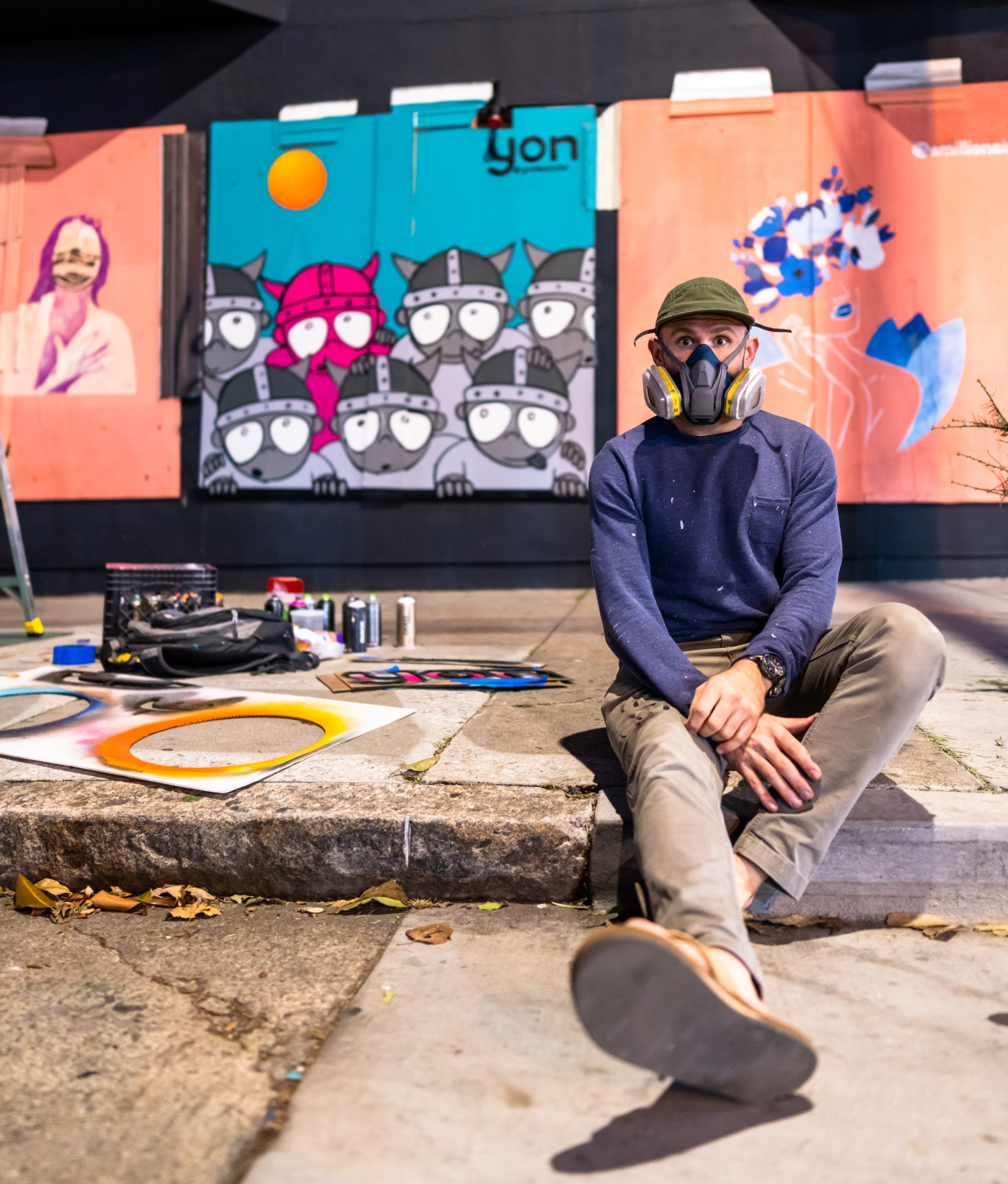Yonmeister sitting in front of his artwork