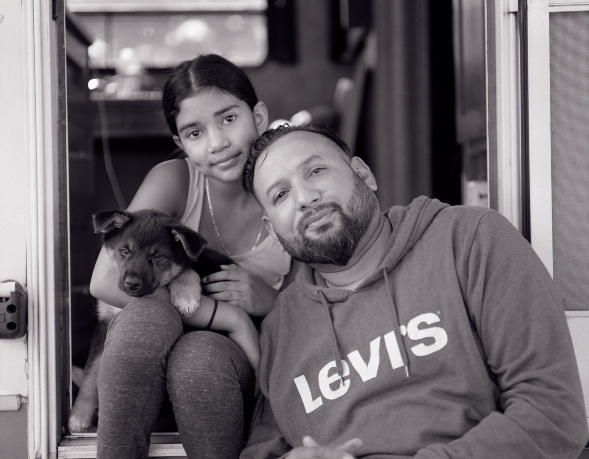 Medina family sitting in the door way of their RV home