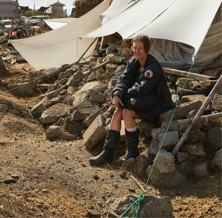 A picture of Lydia, a resident of the Wood Street Commons homeless encampment, sitting on a rock