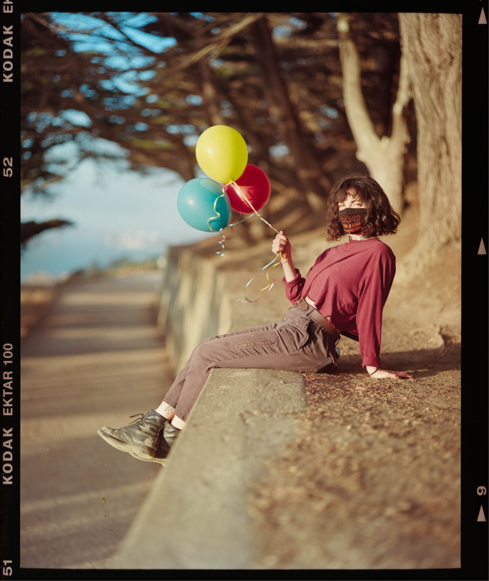 Photograph of Laura posing with some balloons near Lands End during the golden hour