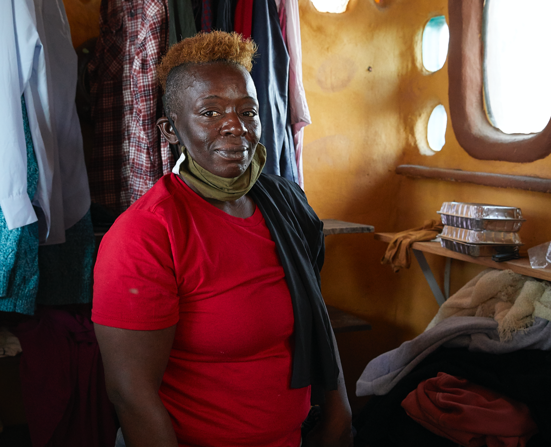 A portrait of Romona, a longtime Wood Street resident, posing inside one of the communal cob structures