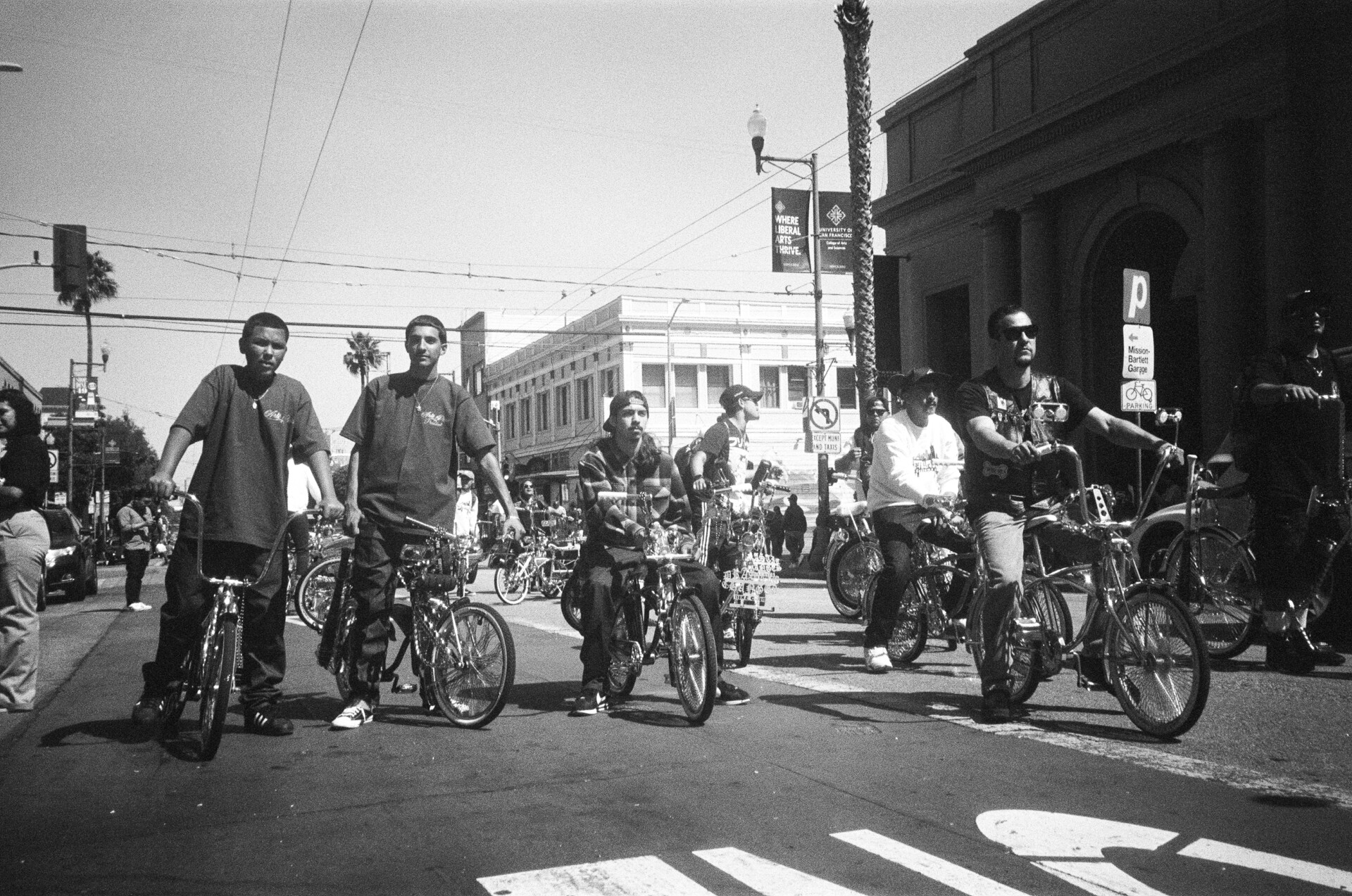 A group of young lowriders on bicycles pose on Mission Street.