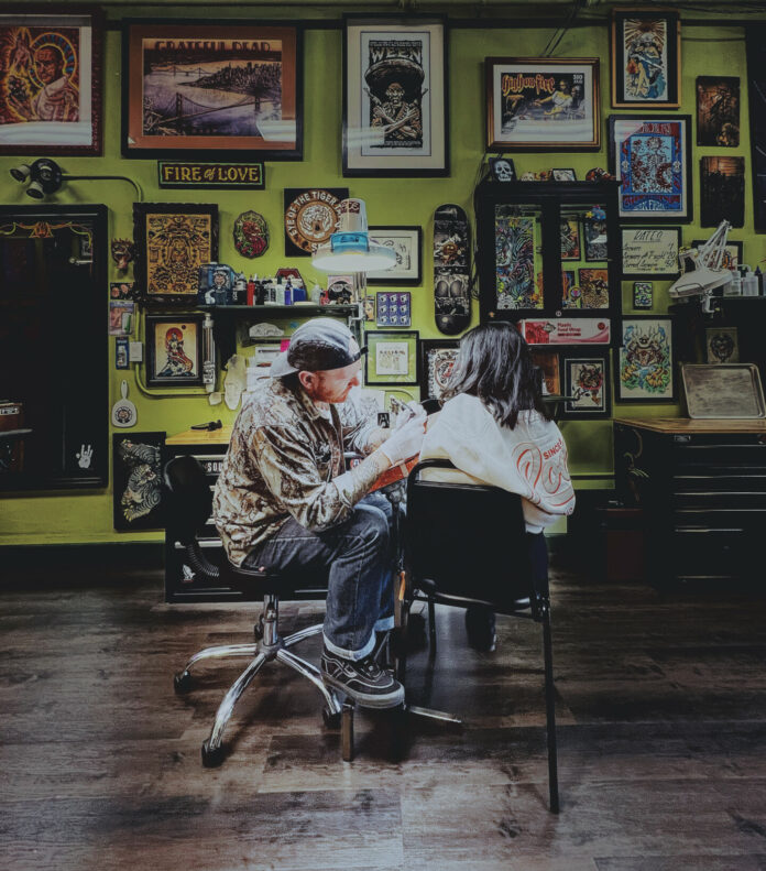 Dustin Grey tattoos a client at Eye of the Tiger Tattoo.